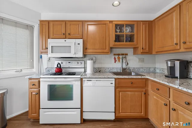a kitchen with cabinets appliances a sink and a window
