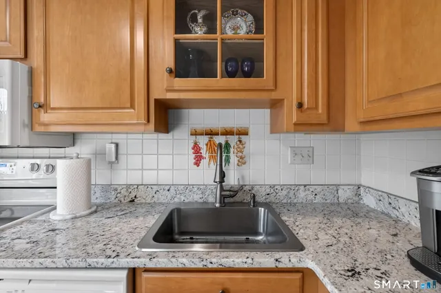 a kitchen with granite countertop a sink and a stove