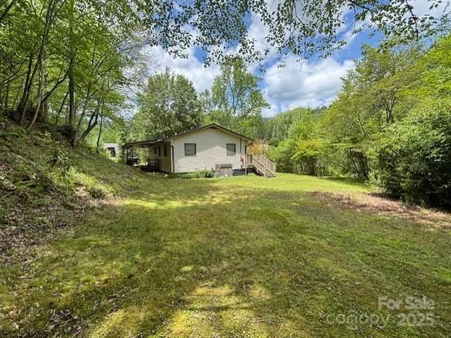 a view of a big yard with large trees