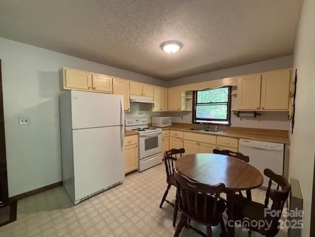 a kitchen with refrigerator cabinets dining table and chairs