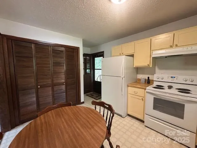 a kitchen with wooden cabinets and white appliances