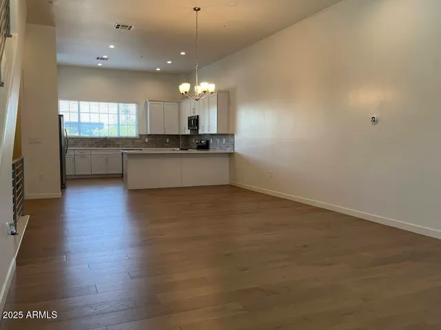an entryway in a hall with a window and wooden floor