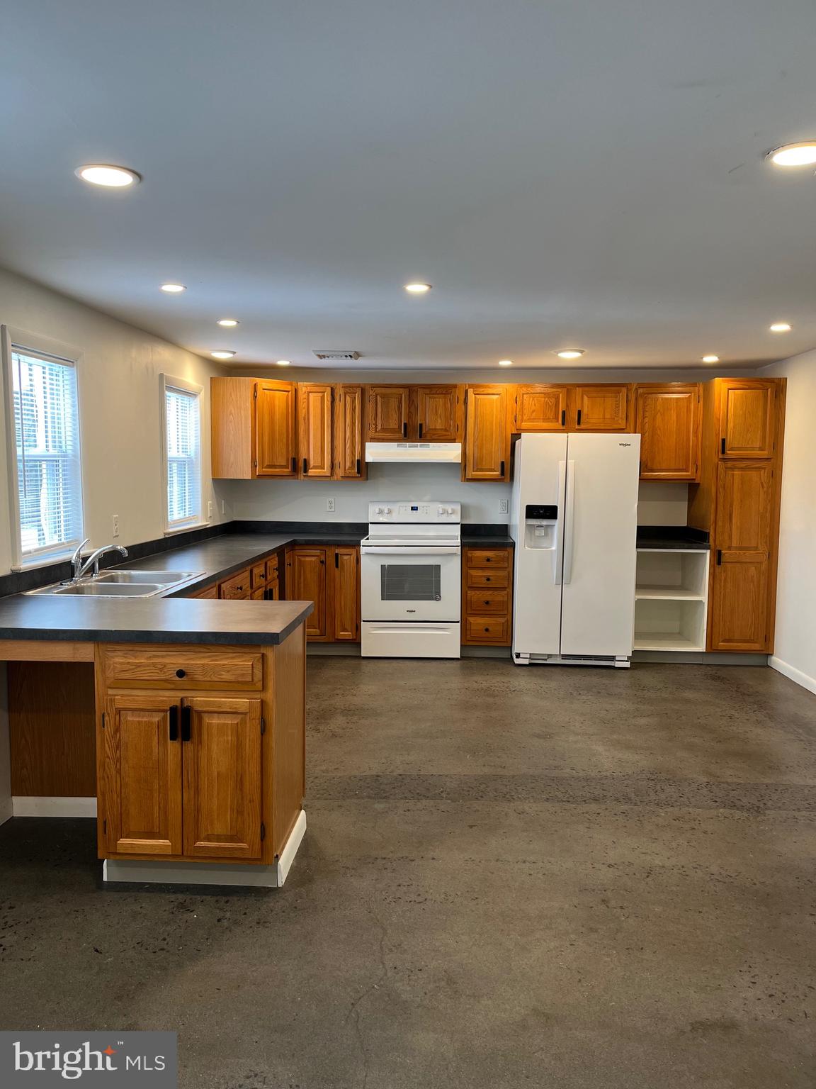 a kitchen with stainless steel appliances granite countertop a stove a sink and a refrigerator