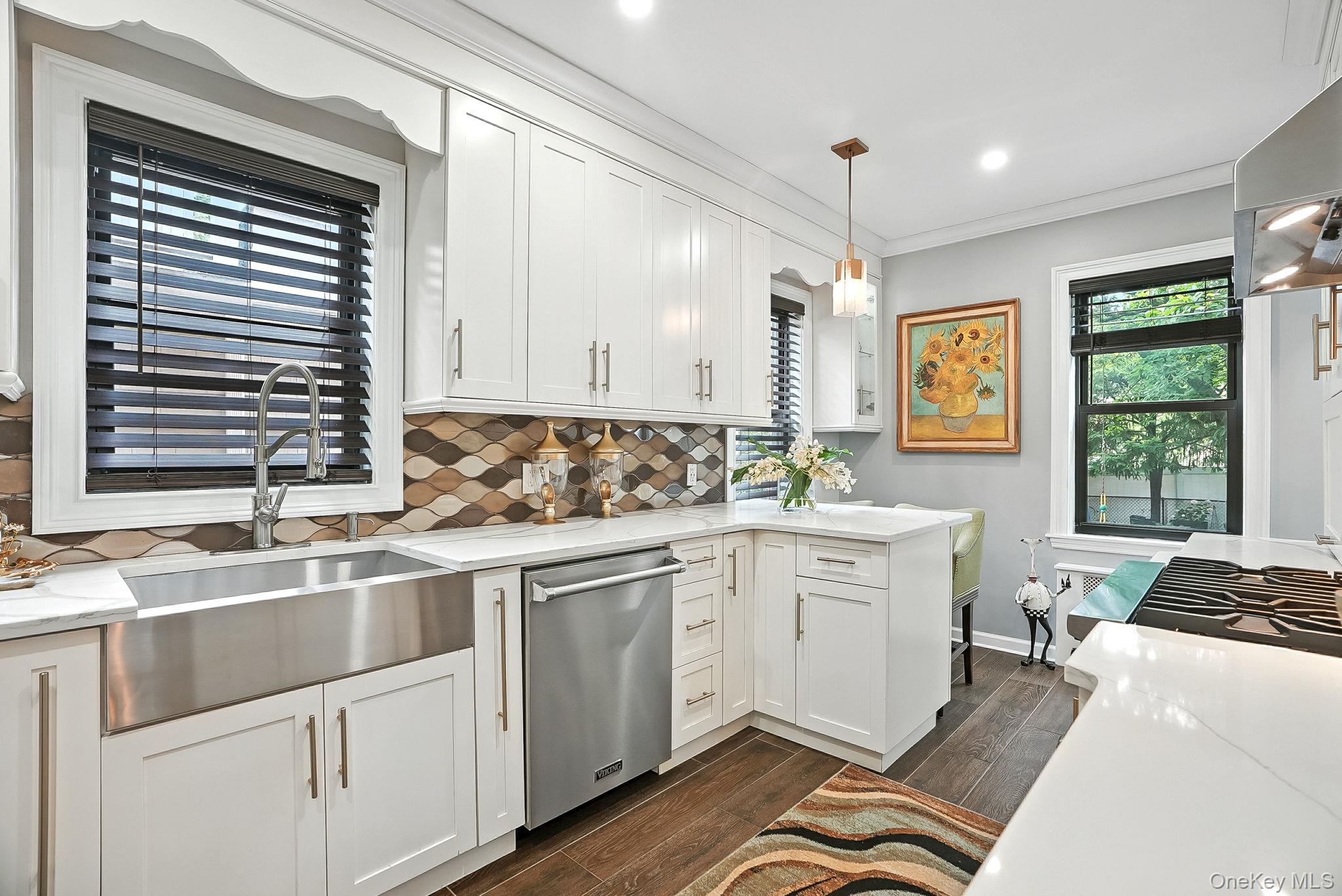 1260 Rhinelander Avenue Bronx, NY 10461 - Photo 16 of 50 Kitchen featuring tasteful backsplash, light stone countertops, dark wood-type flooring, crown molding, and recessed lighting
