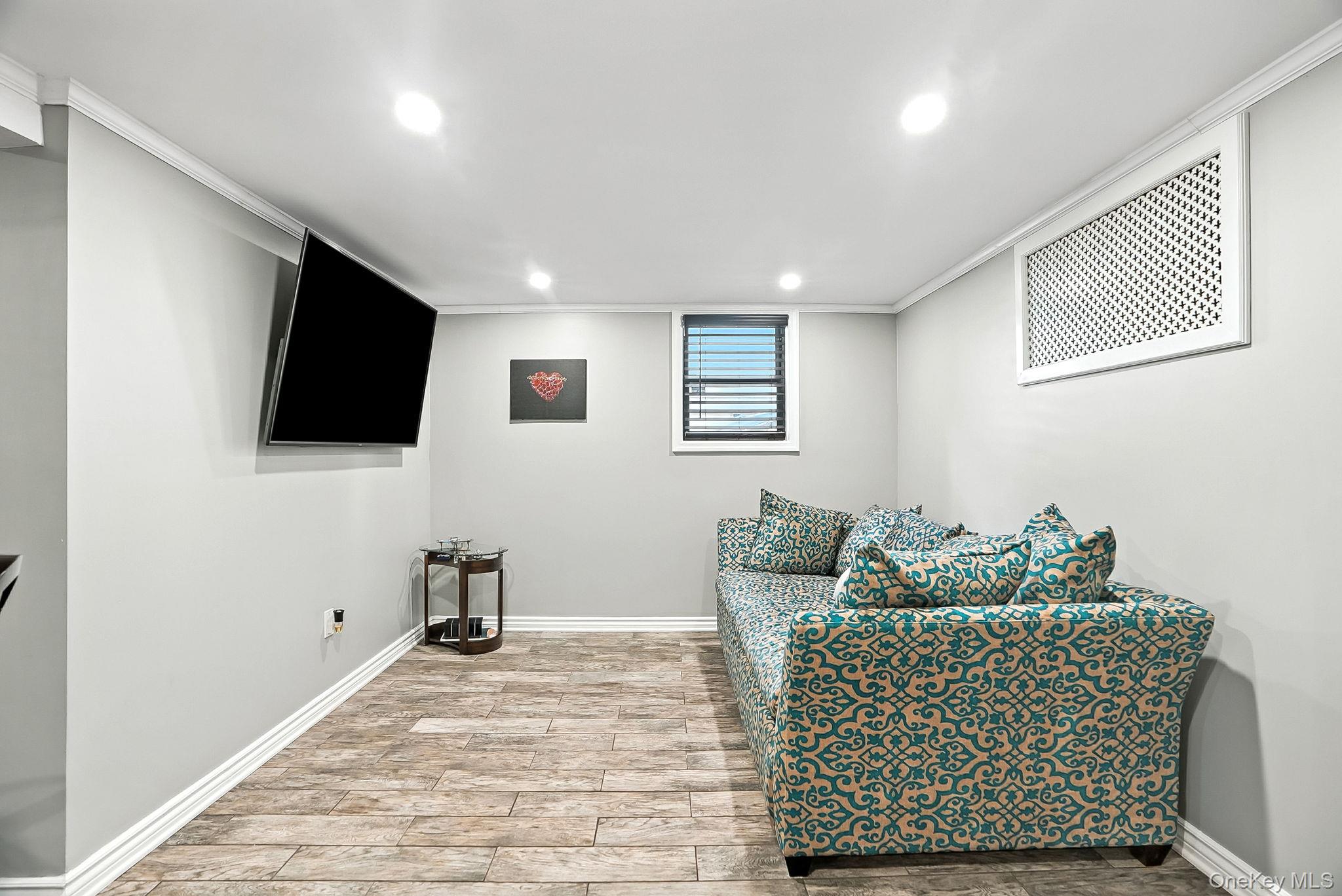 1260 Rhinelander Avenue Bronx, NY 10461 - Photo 29 of 50 Living area featuring light wood finished floors, recessed lighting, and crown molding