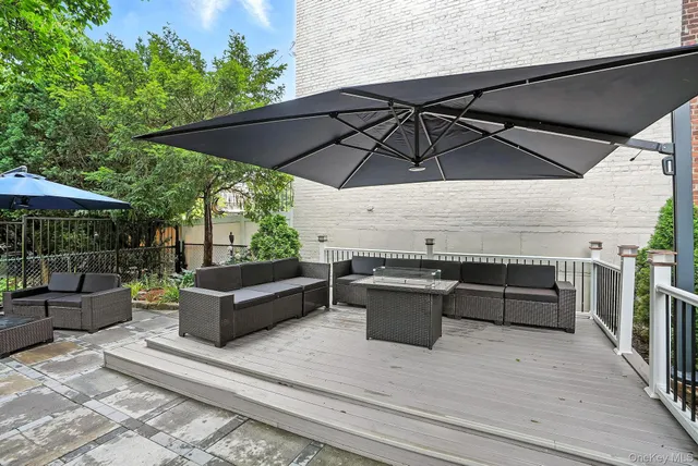 an outdoor sitting area with furniture and umbrella