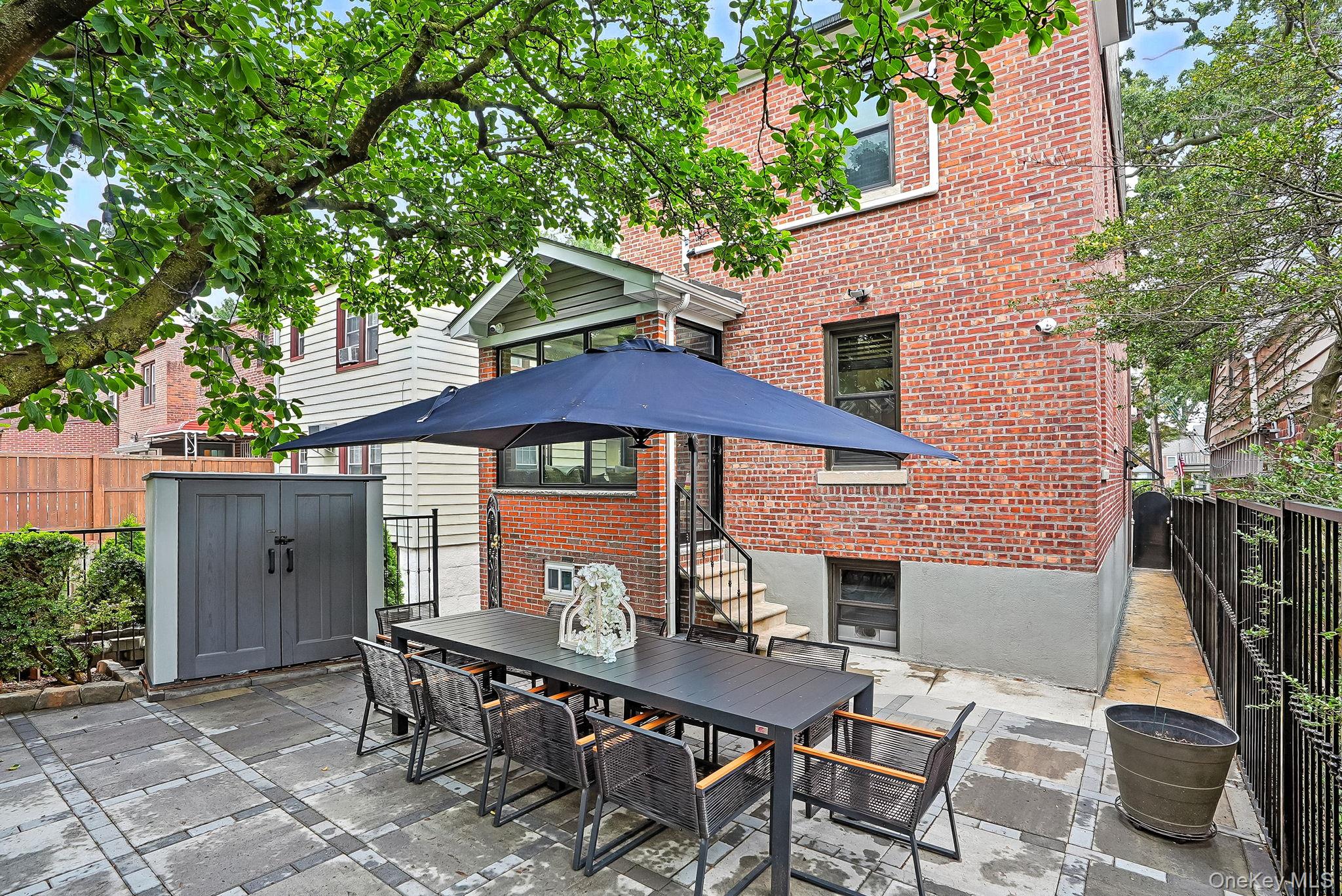 1260 Rhinelander Avenue Bronx, NY 10461 - Photo 40 of 50 Fenced backyard featuring a patio, outdoor dining space, a shed, and entry steps