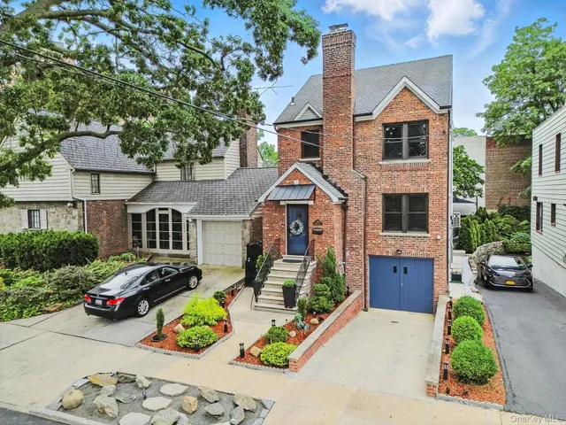 a front view of a house with a garden and parking
