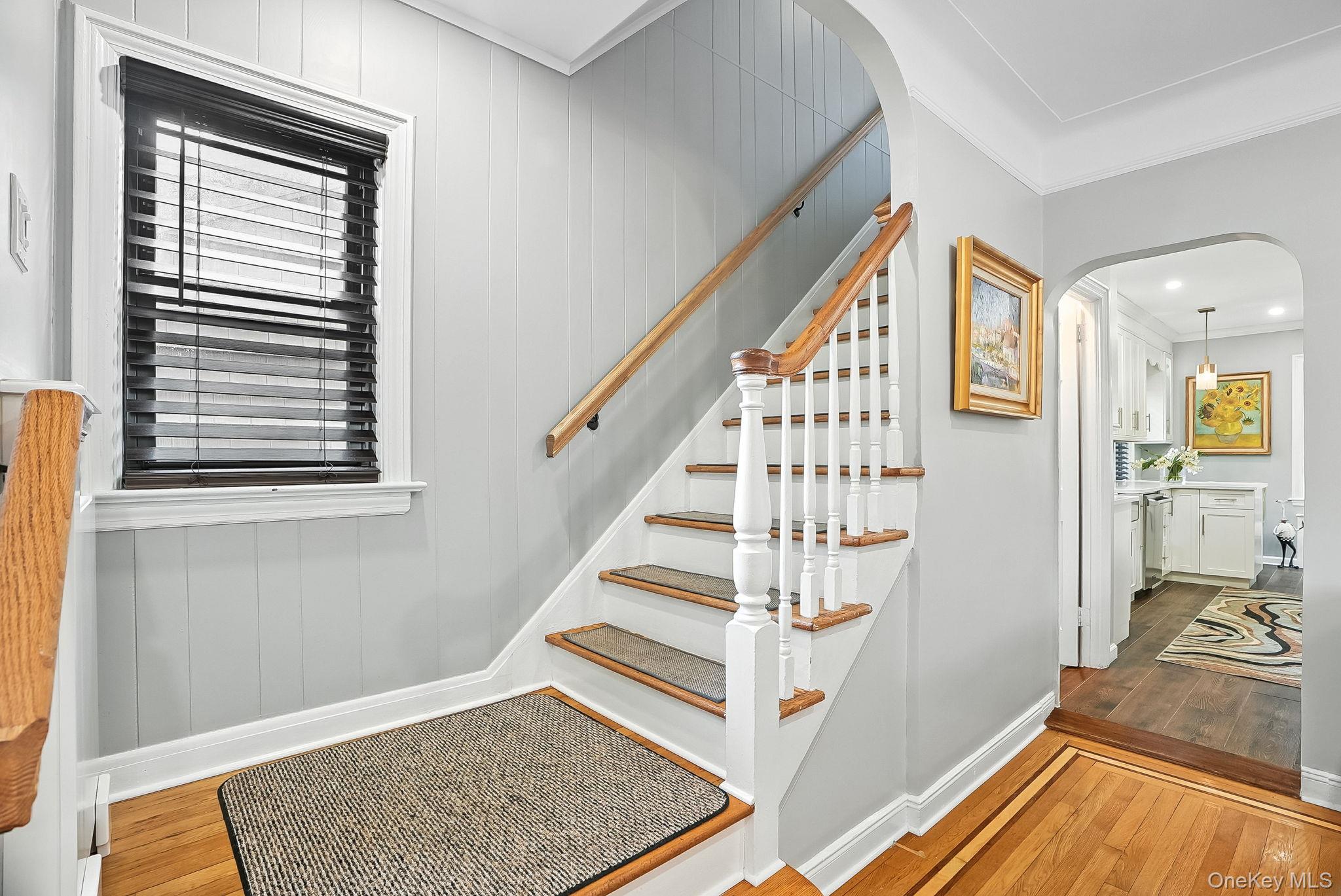 1260 Rhinelander Avenue Bronx, NY 10461 - Photo 8 of 50 Stairway featuring arched walkways, hardwood / wood-style floors, and crown molding