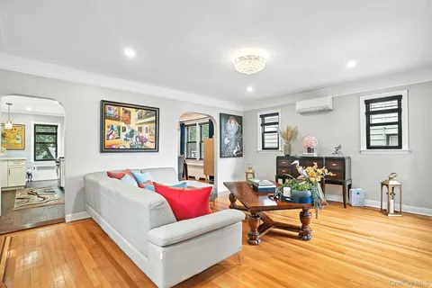 a living room with furniture and painting on the wall next to a window
