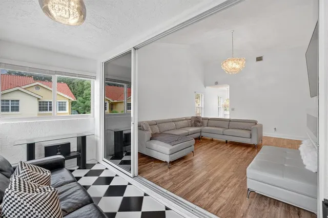 a dining room with wooden floor a chandelier a wooden table and chairs
