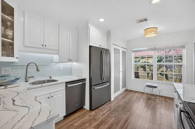 a kitchen with stainless steel appliances granite countertop a refrigerator and a stove top oven
