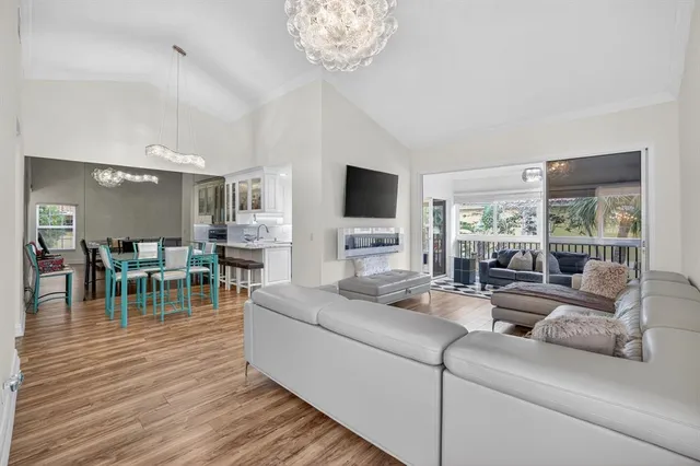 a living room with furniture a flat screen tv and a large window