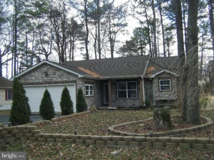 a view of a wooden house with large trees