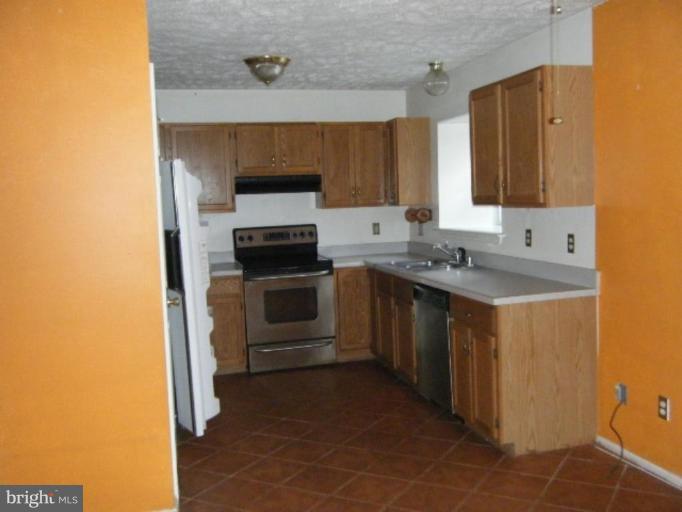 987 Crystal Rock Road Lusby, MD 20657 - Photo 11 of 14 a kitchen with a sink stove and cabinets