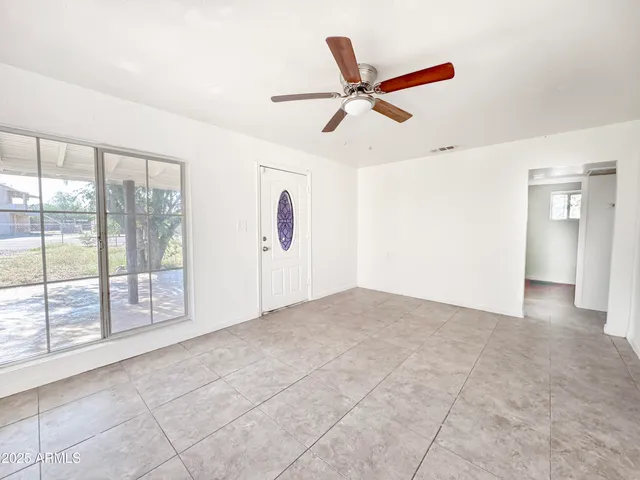 a view of a livingroom with a ceiling fan and window