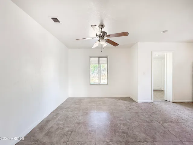 a view of a livingroom with a ceiling fan and window
