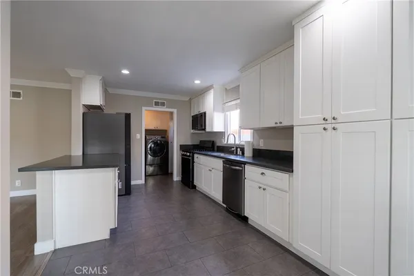 a kitchen with stainless steel appliances granite countertop a stove a sink and a refrigerator
