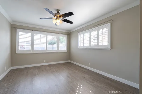 a view of a hallway with wooden floor and a living room