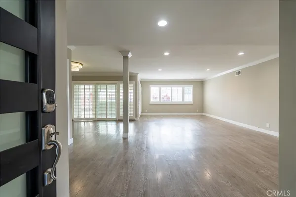 an empty room with wooden floor and windows