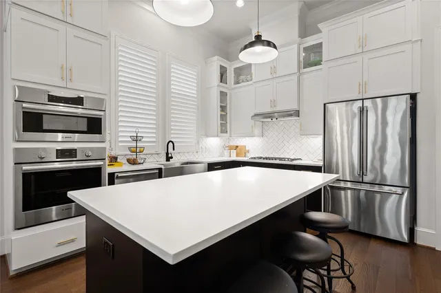 a kitchen with kitchen island a stove a sink and a refrigerator