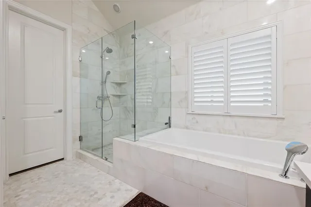 a bathroom with a tub sink and mirror