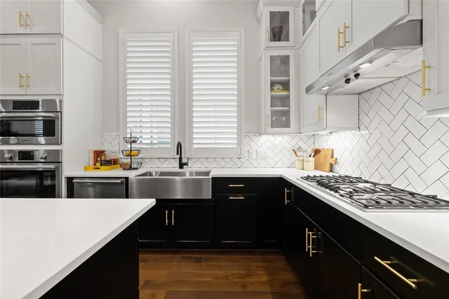 a kitchen with stainless steel appliances sink stove and cabinets