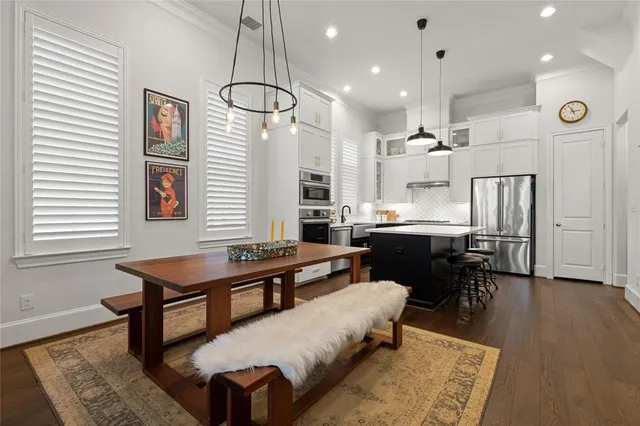 a living room with kitchen island furniture wooden floor and a chandelier