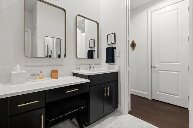 a bathroom with double vanity and a mirror