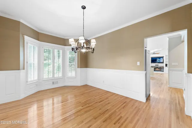 a view of empty room with wooden floor and window