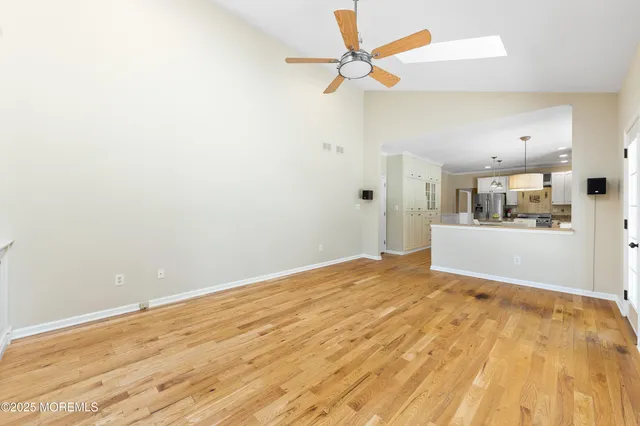 a view of a kitchen with wooden floor and a ceiling fan