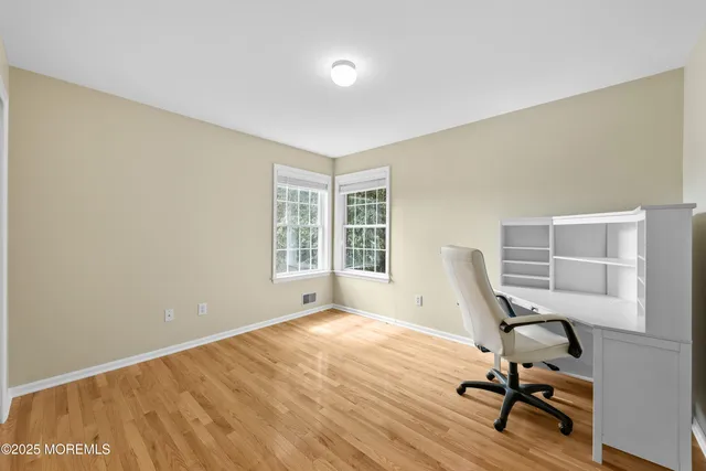 a view of a workspace with furniture and a window