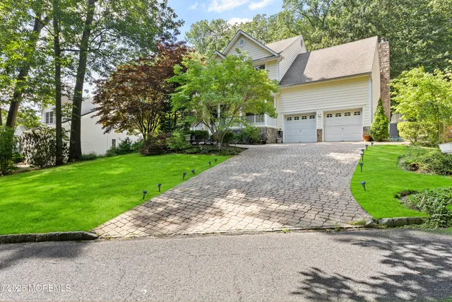 a view of a house with a yard and large tree