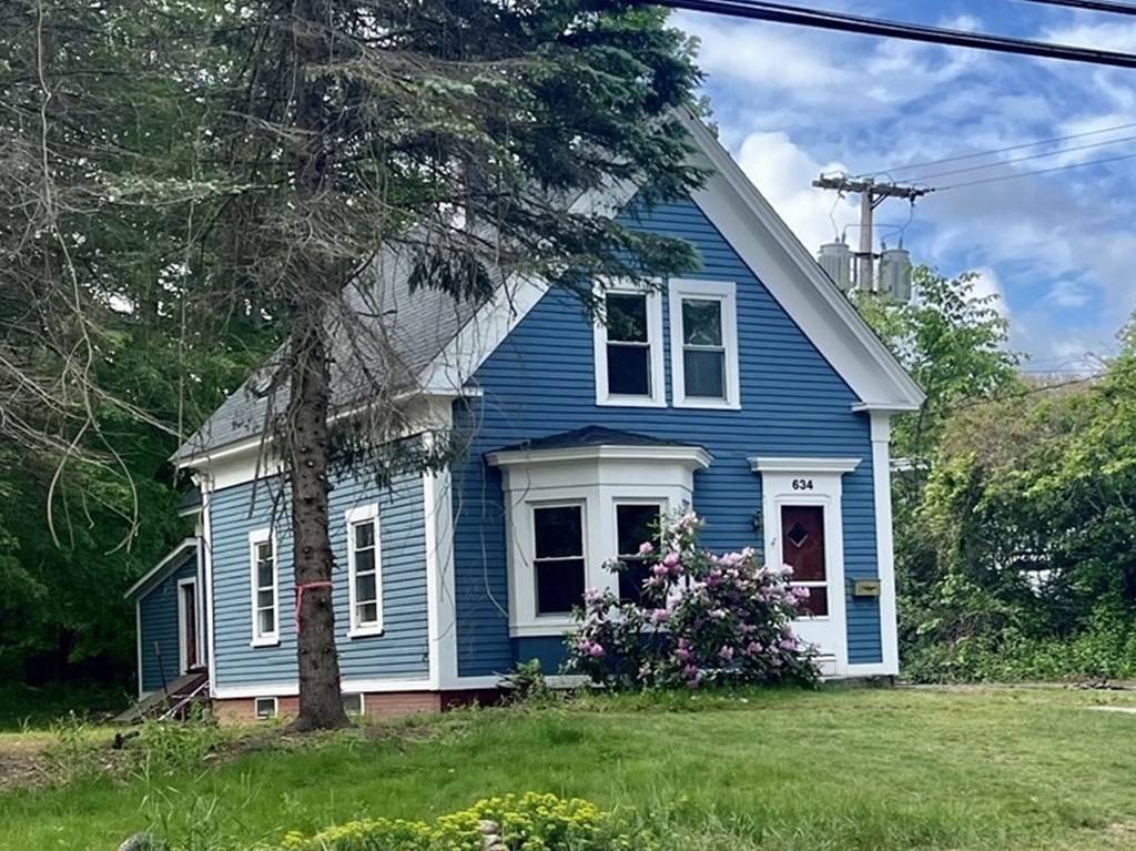 a front view of a house with a garden and plants