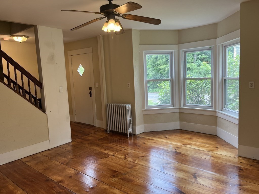634 Patriots Road Templeton, MA 01468 - Photo 16 of 26 an empty room with wooden floor fan and windows