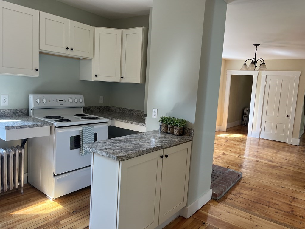 634 Patriots Road Templeton, MA 01468 - Photo 6 of 26 a kitchen with granite countertop a stove a sink and a refrigerator