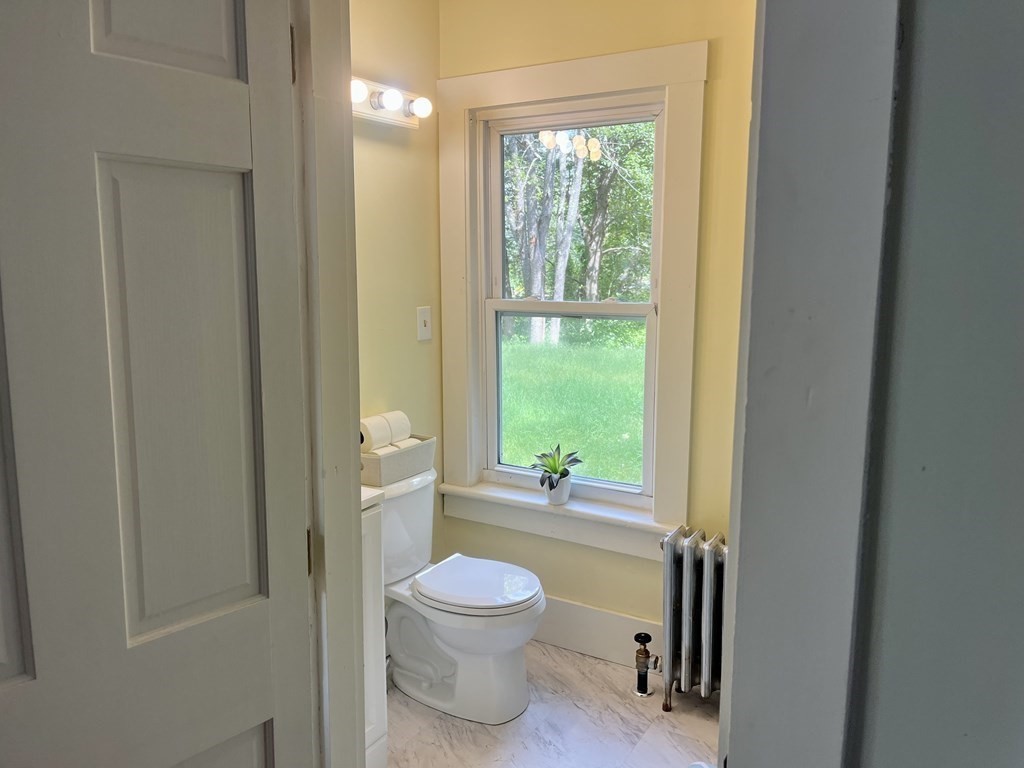 634 Patriots Road Templeton, MA 01468 - Photo 8 of 26 a bathroom with a toilet a sink and a large window