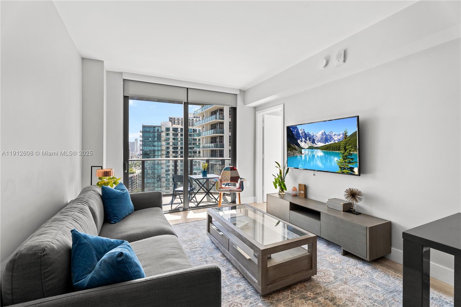 121 Northeast 34th Street, Unit 2003 Miami, FL 33137 - Photo 11 of 27 a living room with furniture and a flat screen tv