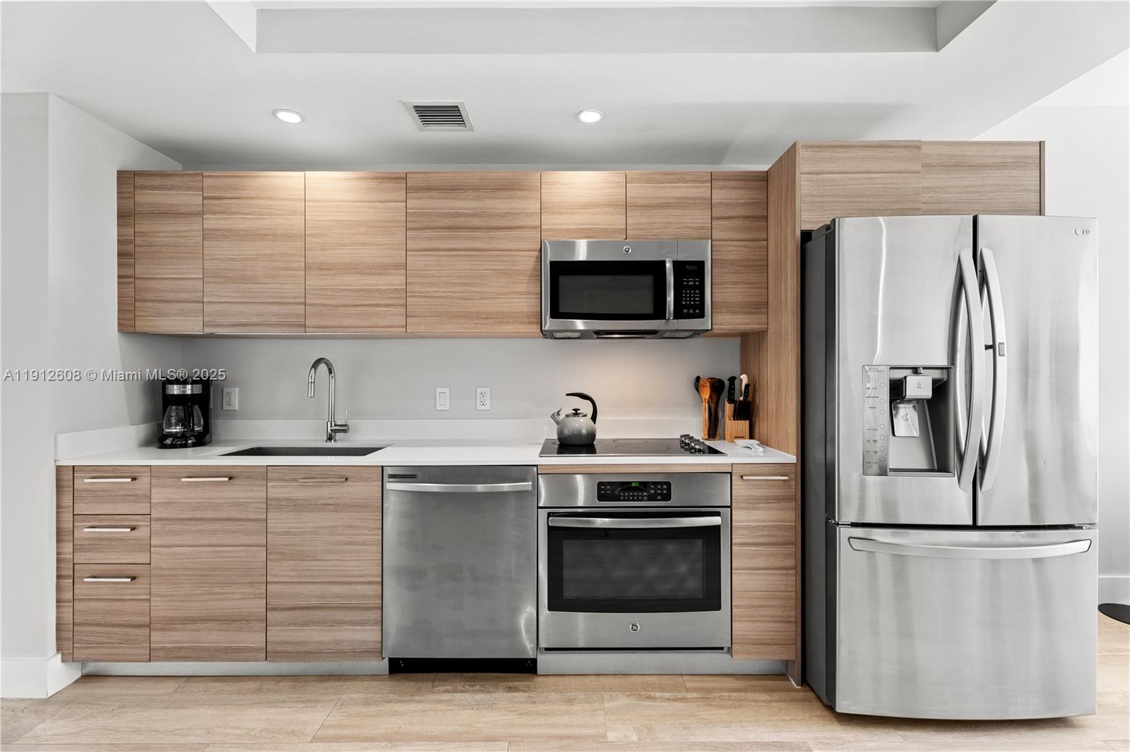 121 Northeast 34th Street, Unit 2003 Miami, FL 33137 - Photo 12 of 27 a kitchen with stainless steel appliances a refrigerator stove and microwave