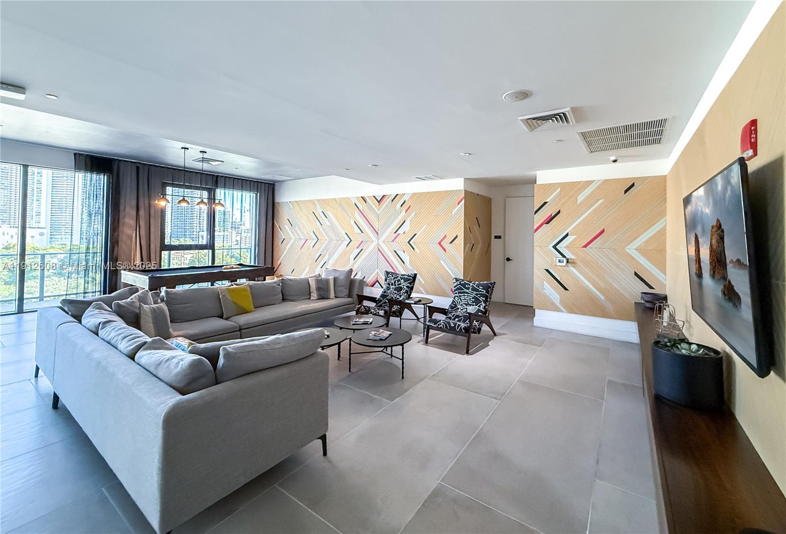 121 Northeast 34th Street, Unit 2003 Miami, FL 33137 - Photo 23 of 27 a living room with furniture a flat screen tv and a large window