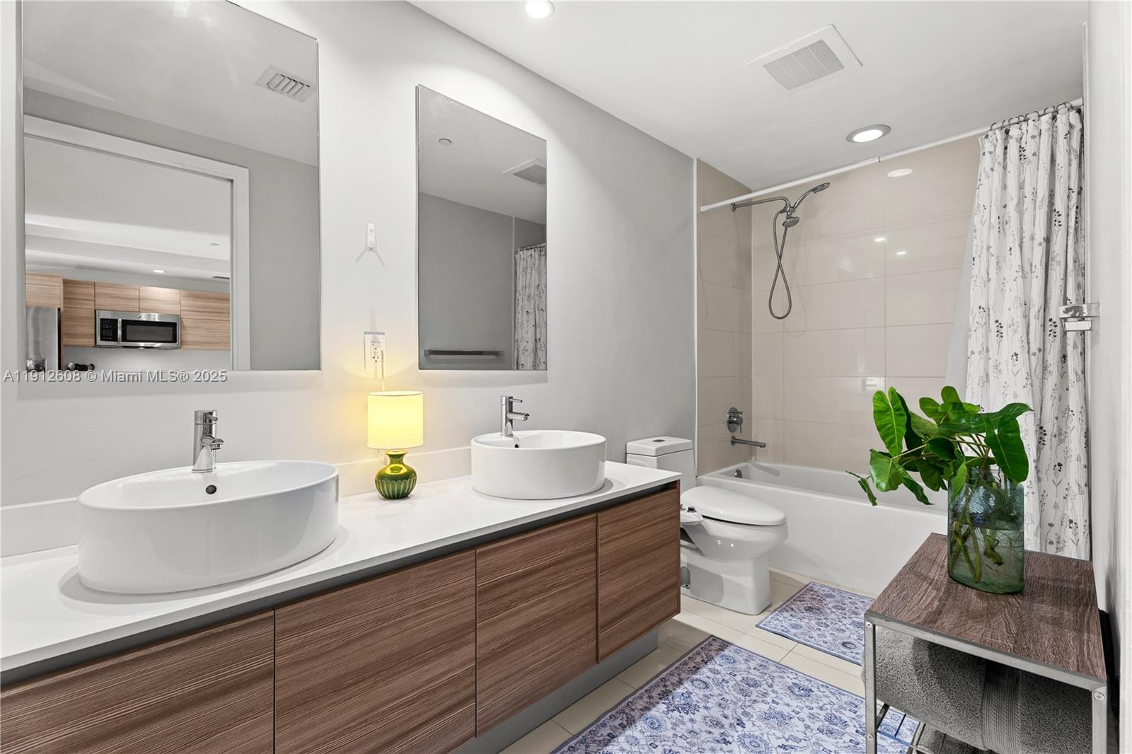 121 Northeast 34th Street, Unit 2003 Miami, FL 33137 - Photo 6 of 27 a bathroom with a double vanity sink toilet and a mirror