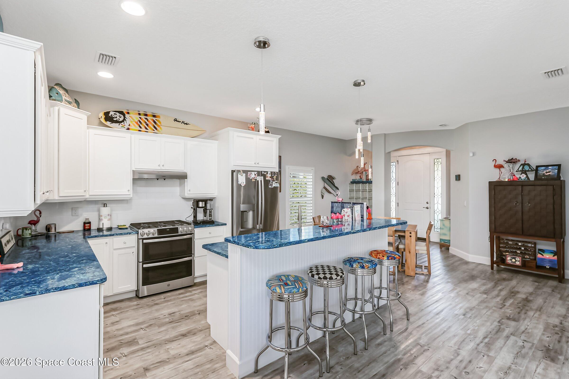 1399 Tullagee Avenue Melbourne, FL 32940 - Photo 12 of 53 a kitchen with kitchen island a counter top space a sink stainless steel appliances and cabinets