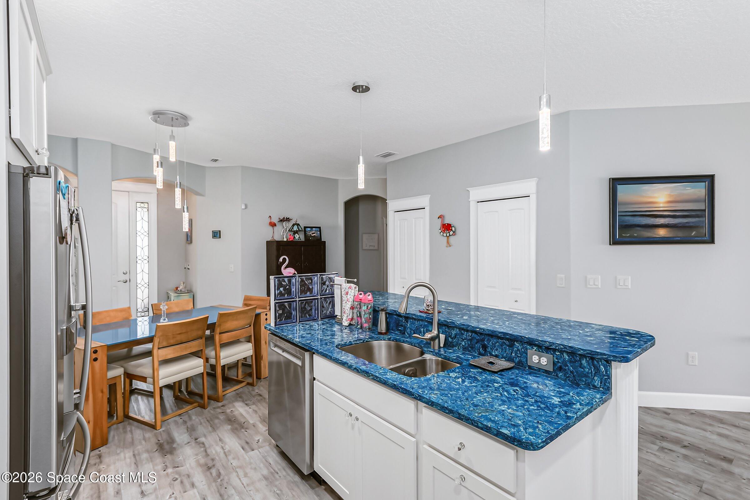 1399 Tullagee Avenue Melbourne, FL 32940 - Photo 14 of 53 a kitchen with granite countertop a sink dining table and chairs