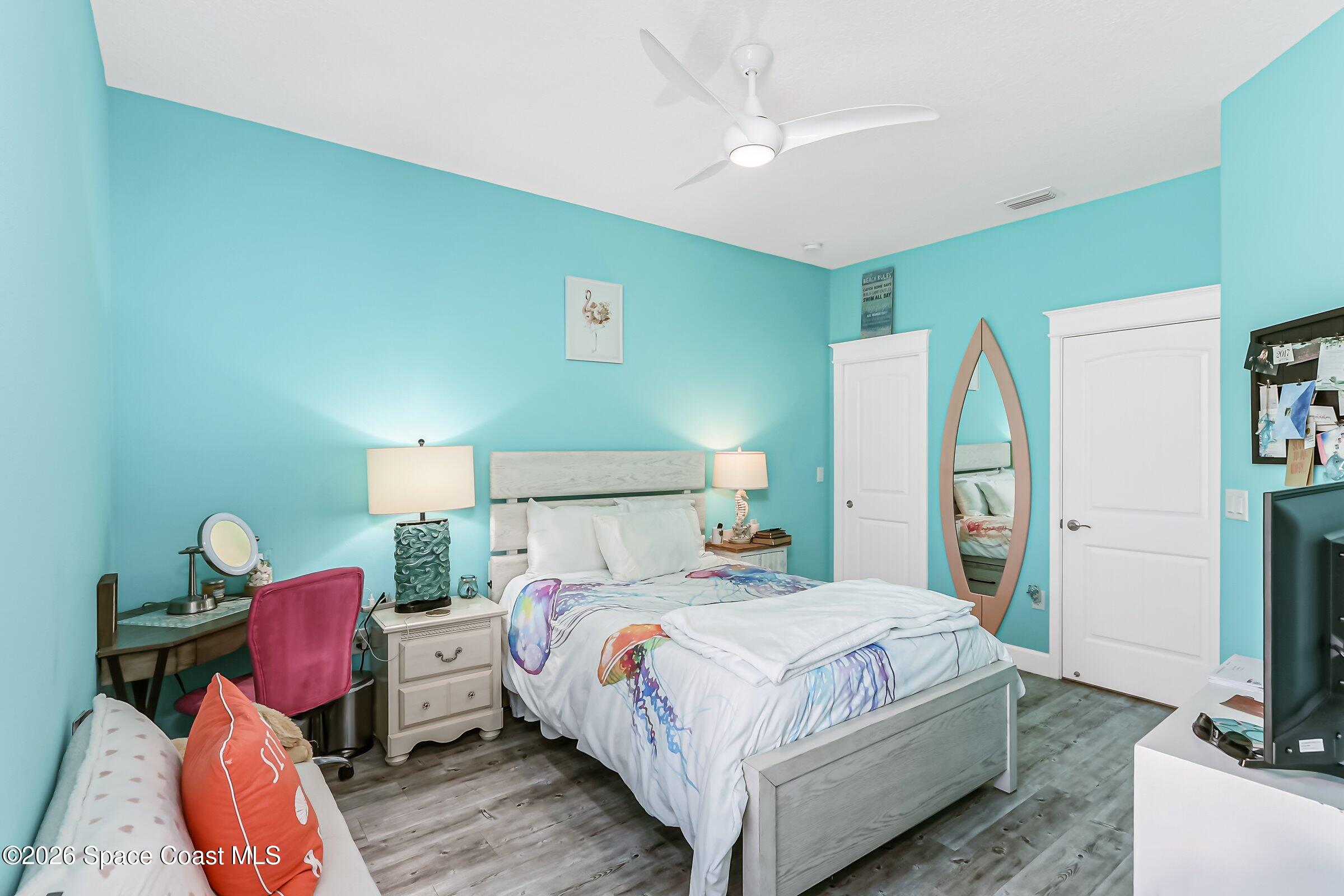 1399 Tullagee Avenue Melbourne, FL 32940 - Photo 23 of 53 a bedroom with a bed table and a flat screen tv