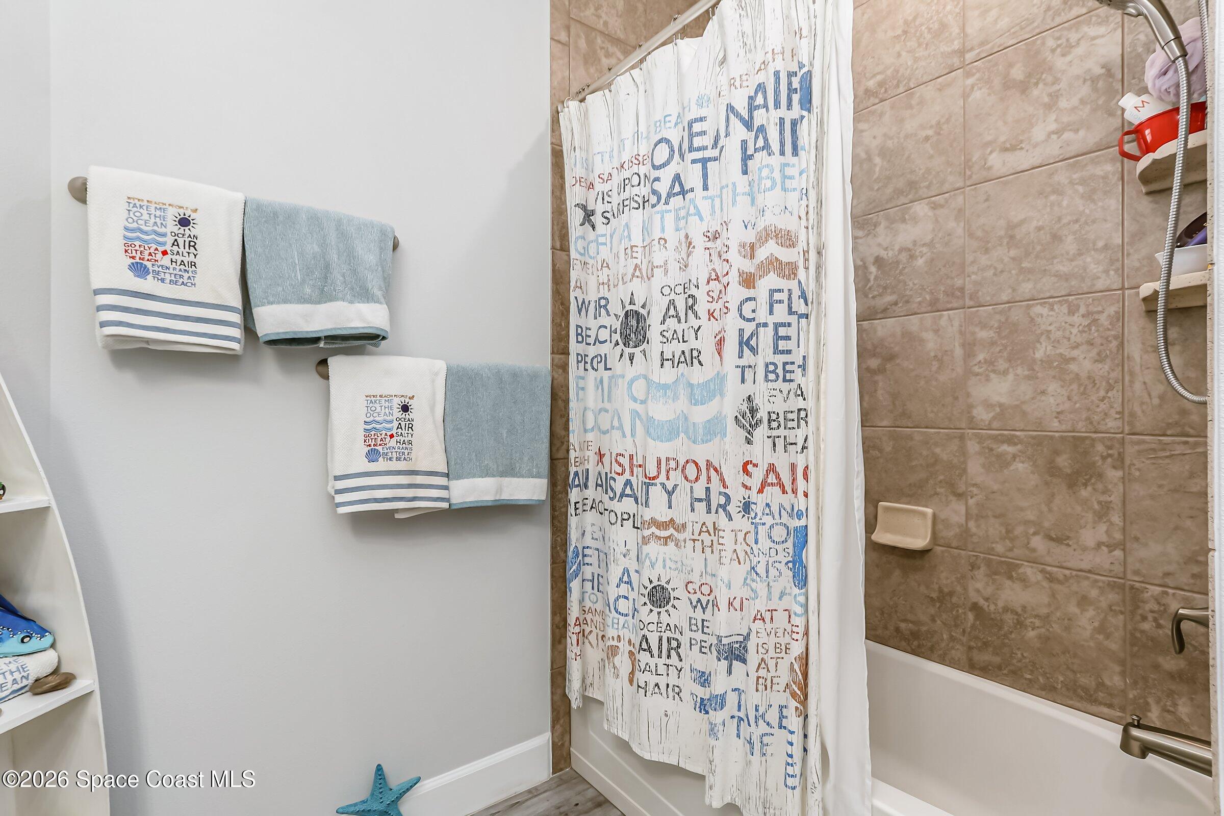 1399 Tullagee Avenue Melbourne, FL 32940 - Photo 27 of 53 a bathroom with a shower and a shower curtain