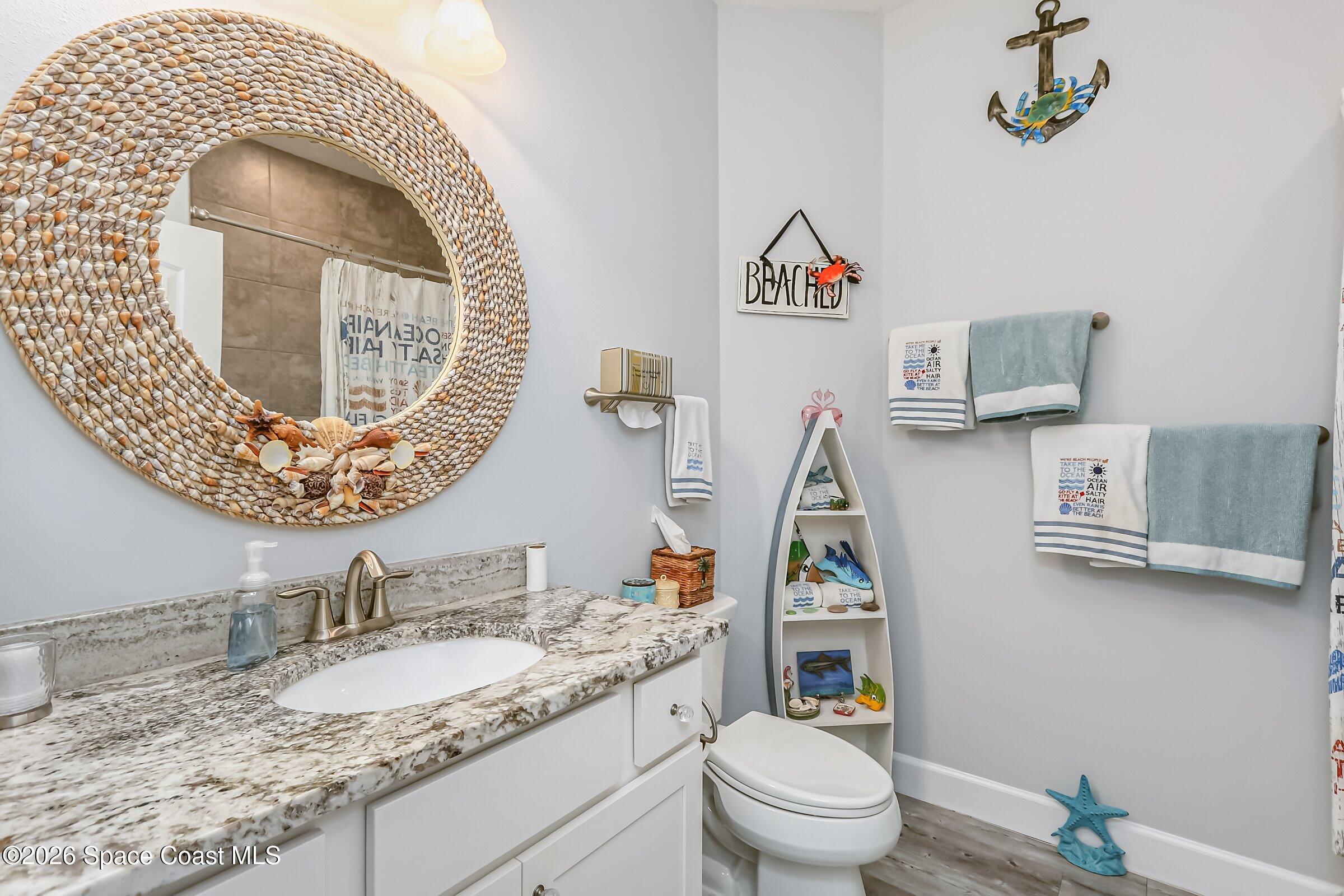 1399 Tullagee Avenue Melbourne, FL 32940 - Photo 28 of 53 a bathroom with a toilet a sink and mirror