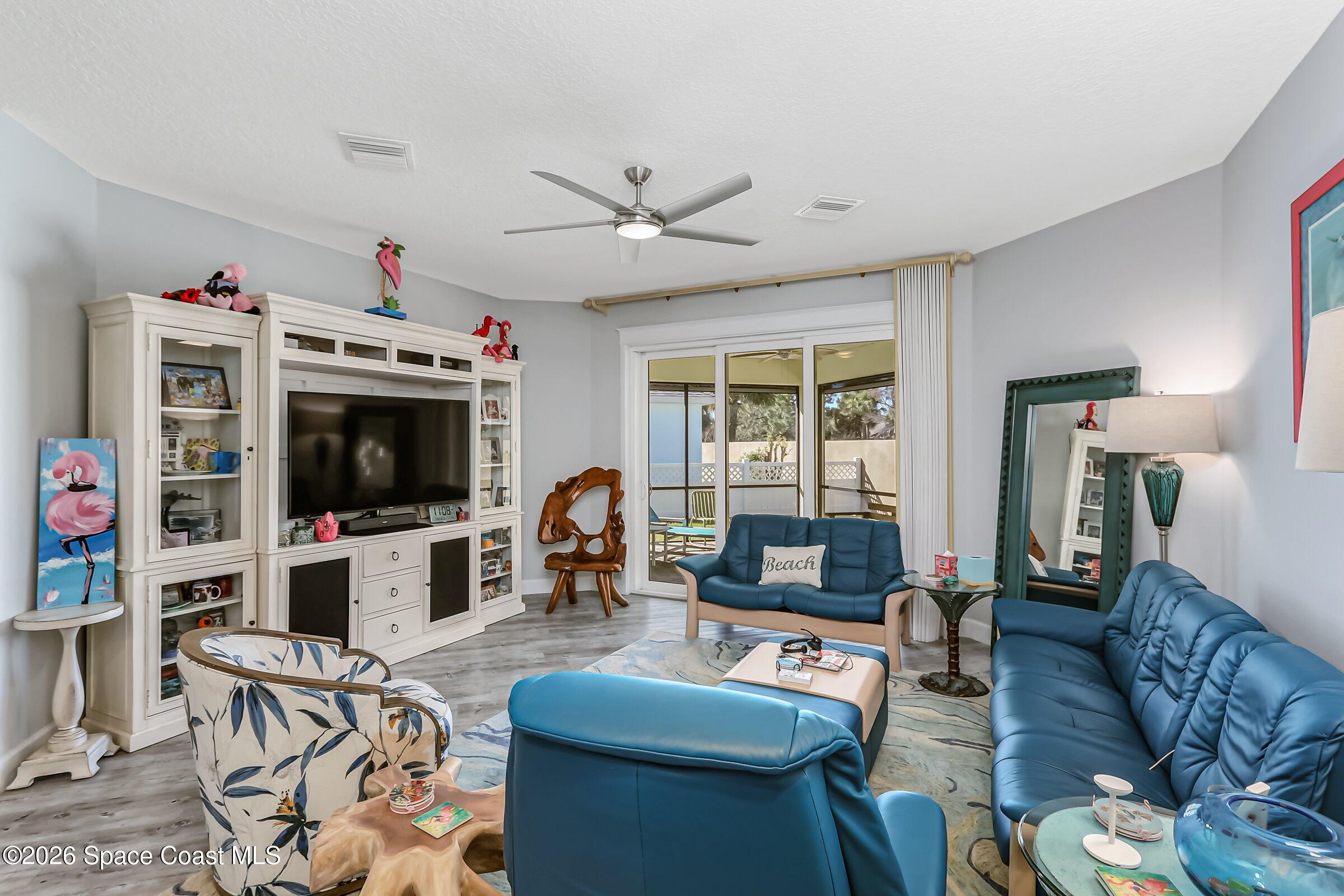 1399 Tullagee Avenue Melbourne, FL 32940 - Photo 10 of 53 a living room with furniture a flat screen tv and kitchen view