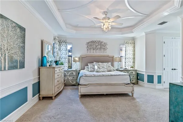 a spacious bedroom with a bed and a chandelier