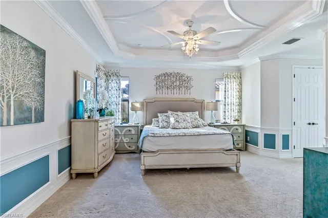 a spacious bedroom with a bed and a chandelier