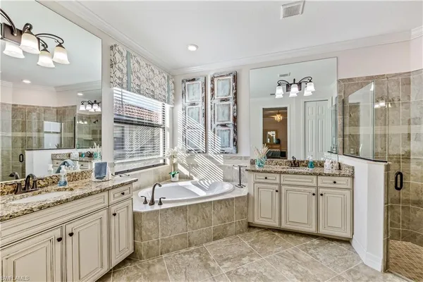a spacious bathroom with sinks mirror and a bathtub